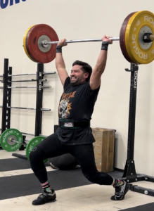 Man performing clean and jerk with 100kg