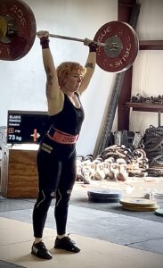 Woman performing clean and jerk with 73kg