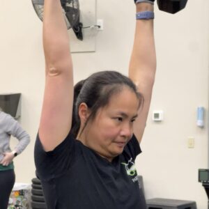 Woman performing overhead press with dumbbells