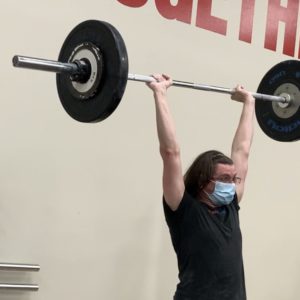 man holding barbell overhead