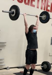 Man standing with barbell overhead