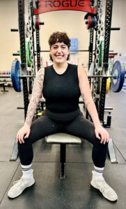 Woman sitting on bench press in gym
