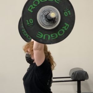 Female performing jerk portion of clean and jerk