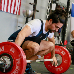 Male weightlifter preparing to perform a snatch