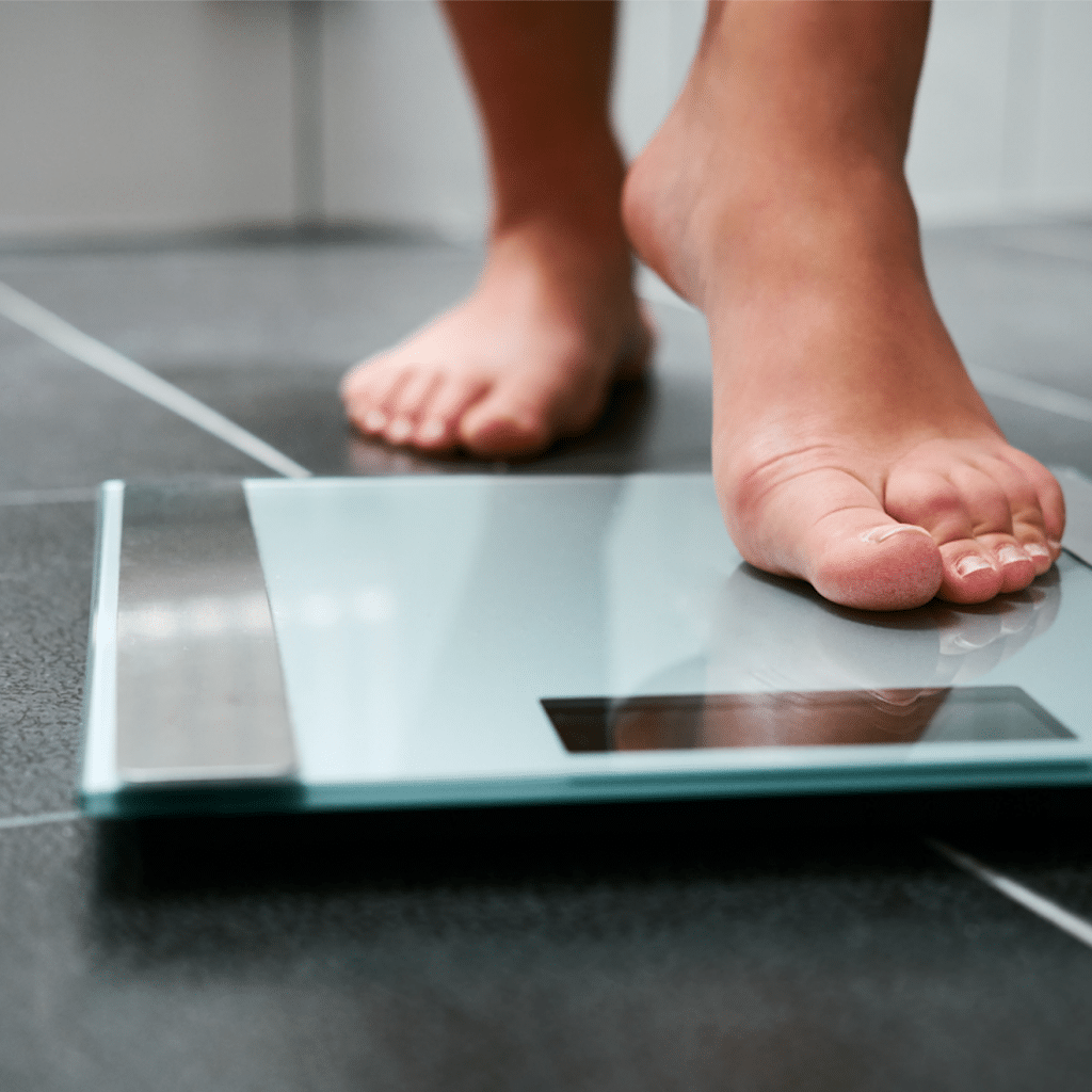 Female Bare Feet Stepping on Weight Scale