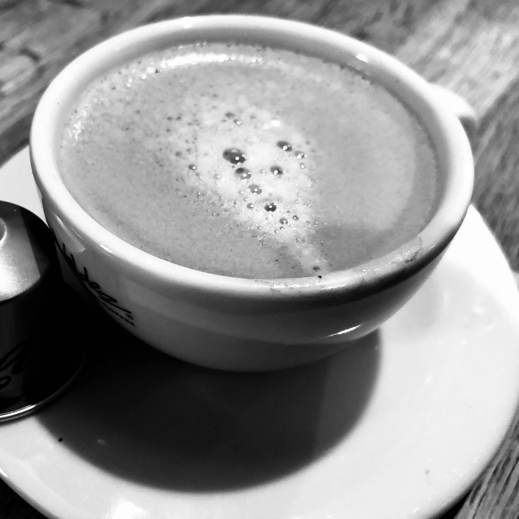 Nespresso pod next to a cup of espresso